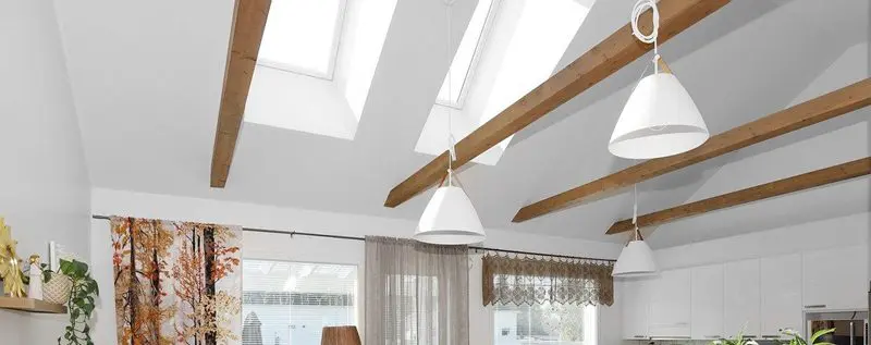 Modern kitchen with skylights and wooden beams.