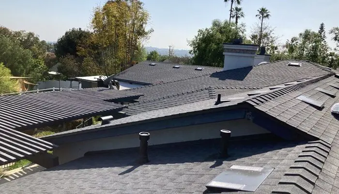Multiple rooftops with trees in the background.
