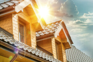 A sun shining on the roof of a house.