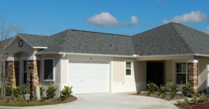 A white garage with a blue roof and a sky background